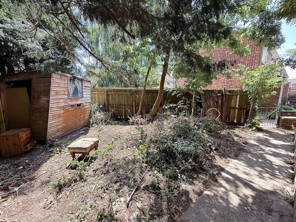 Lot: 99 - THREE-BEDROOM END-TERRACE HOUSE IN NEED OF MODERNISATION - Garden shot to the side of property